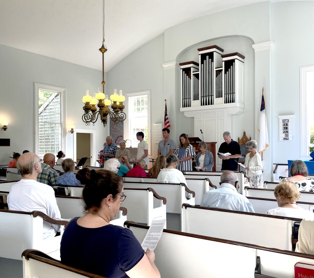 Ian Goff, Brian Kennedy, Virginia Barbatti and Aaron Barbatti standing in front of congregation being welcomed in as church members